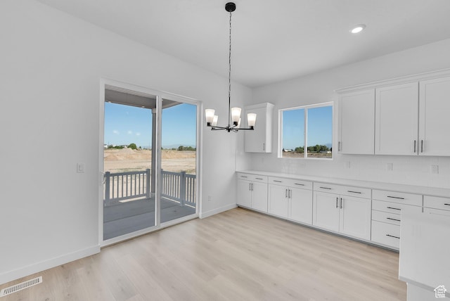 1086 S 3170 E Unit 217, Spanish Fork, UT 84660 - kitchen with light wood-type flooring, white cabinetry, a chandelier, light countertops, and recessed lighting