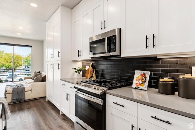 32 W 400 S, Bountiful, UT 84010 - kitchen featuring appliances with stainless steel finishes, dark wood-type flooring, white cabinets, decorative backsplash, and recessed lighting