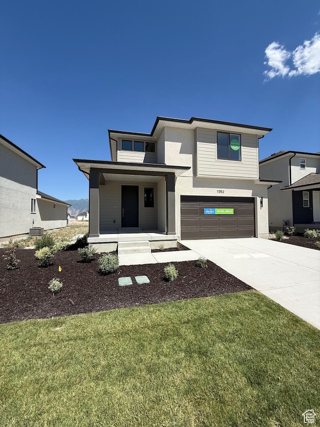 1352 N 1440 E Unit 21, Payson, UT 84651 - view of front of home featuring an attached garage, covered porch, driveway, stucco siding, and a front yard
