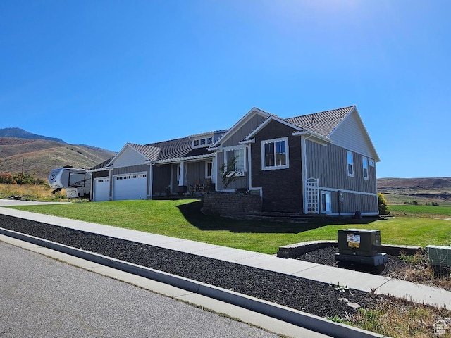 1268 E 300 S, Smithfield, UT 84335 - view of front of property with board and batten siding, a garage, a front yard, and a mountain view