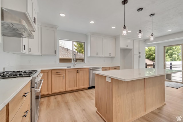 13749 S Crimson Patch Way, Riverton, UT 84096 - kitchen with appliances with stainless steel finishes, wall chimney range hood, light wood-type flooring, a kitchen island, and recessed lighting