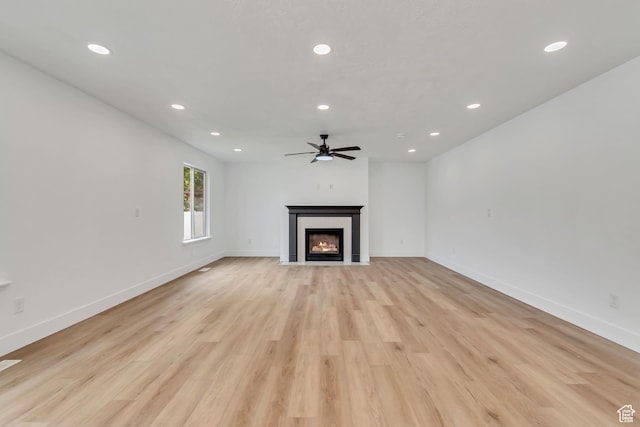 13749 S Crimson Patch Way, Riverton, UT 84096 - unfurnished living room featuring a ceiling fan, recessed lighting, a fireplace with flush hearth, and light wood-type flooring