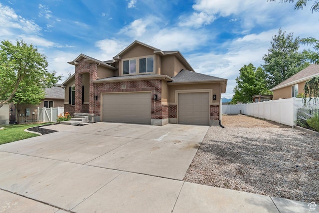 13749 S Crimson Patch Way, Riverton, UT 84096 - view of front of house featuring driveway, stucco siding, brick siding, and an attached garage