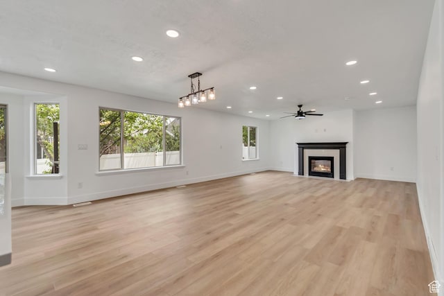 13749 S Crimson Patch Way, Riverton, UT 84096 - unfurnished living room featuring recessed lighting, a glass covered fireplace, light wood-type flooring, and ceiling fan