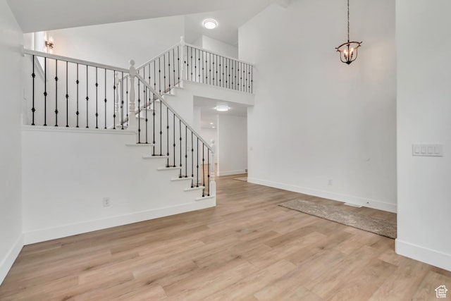 13749 S Crimson Patch Way, Riverton, UT 84096 - stairway featuring a high ceiling, wood finished floors, and a chandelier