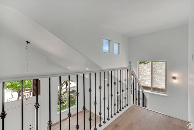 13749 S Crimson Patch Way, Riverton, UT 84096 - hall featuring light wood-type flooring, a towering ceiling, and an upstairs landing