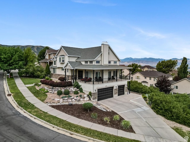 13994 S Stone Dr E, Draper, UT 84020 - view of front facade with a porch, a mountain view, a garage, and a chimney