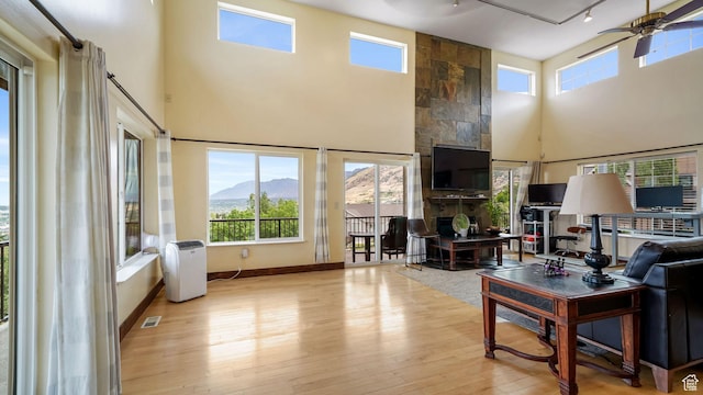 13994 S Stone Dr E, Draper, UT 84020 - living area featuring a high ceiling, wood-type flooring, plenty of natural light, a ceiling fan, and rail lighting