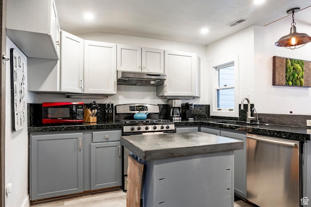 416 Marsac Ave, Park City, UT 84060 - kitchen featuring appliances with stainless steel finishes, under cabinet range hood, dark countertops, a kitchen island, and light wood-style floors