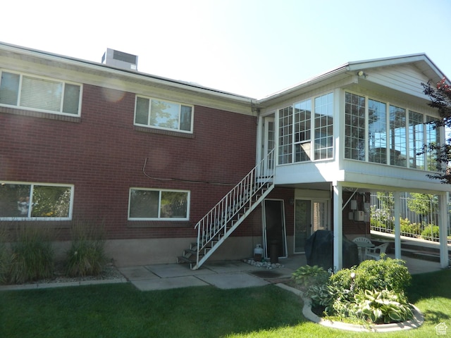 4222 S Edward Dr, Holladay, UT 84124 - back of house with a sunroom, a patio, stairs, and brick siding