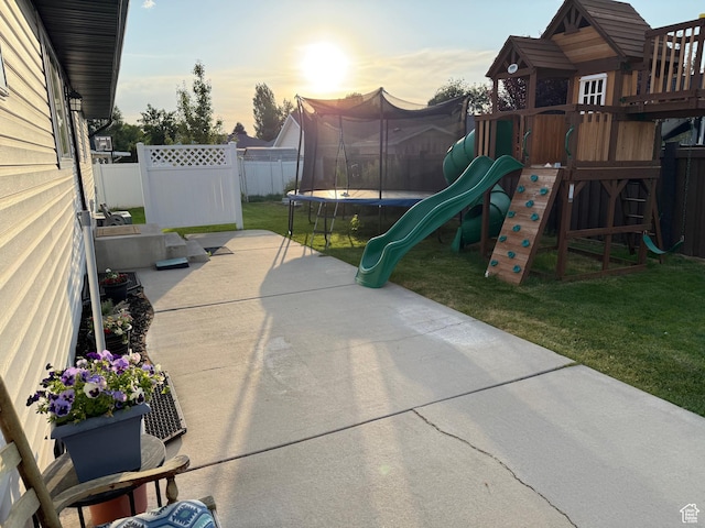 1079 E 850 S, Spanish Fork, UT 84660 - patio terrace at dusk featuring a trampoline, a playground, a patio area, and a fenced backyard