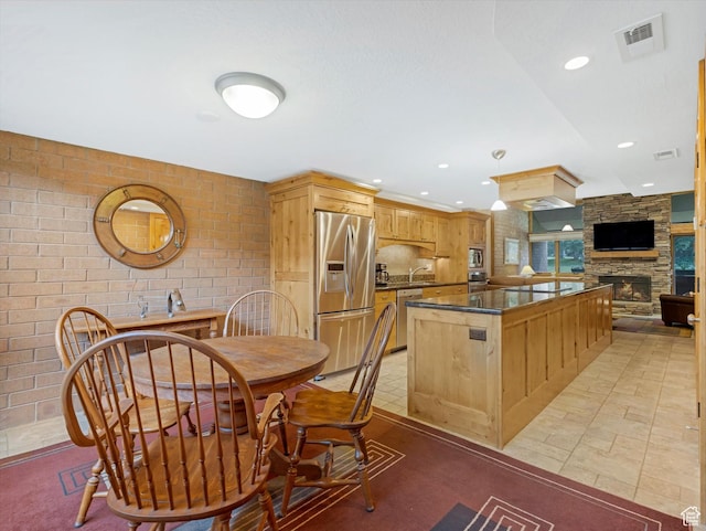 1679 Captain Molly Dr, Park City, UT 84060 - kitchen featuring appliances with stainless steel finishes, dark countertops, a stone fireplace, a center island, and recessed lighting
