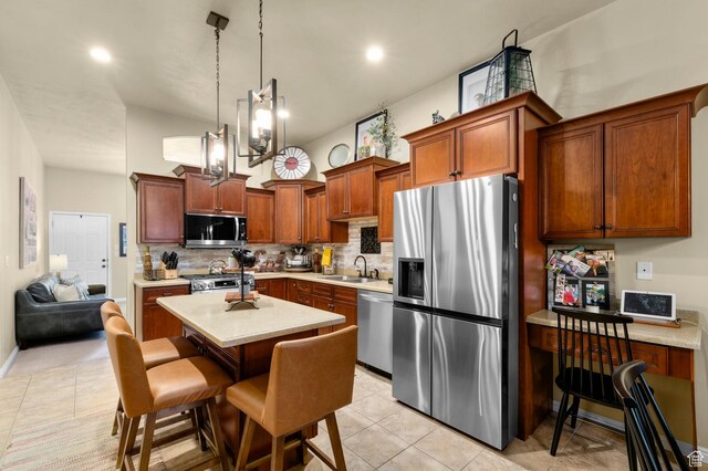 14858 S Ox Cart Ln, Draper, UT 84020 - kitchen featuring appliances with stainless steel finishes, tasteful backsplash, light countertops, light tile patterned floors, and a kitchen island