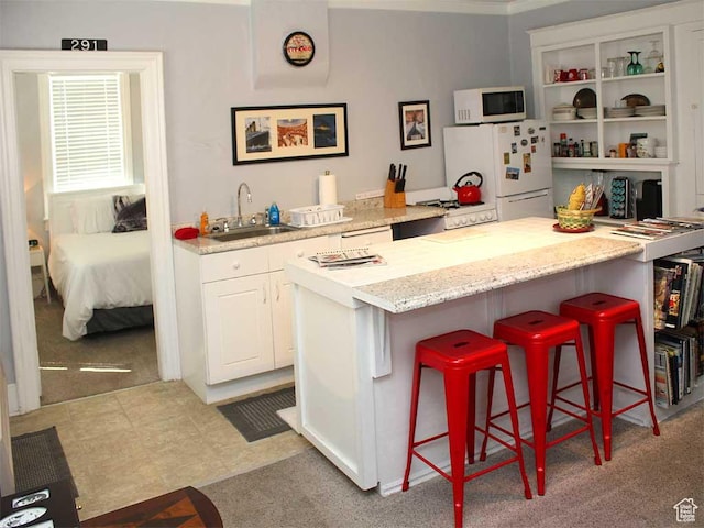 291 E 300 N Unit A, Heber City, UT 84032 - kitchen with white appliances, a kitchen breakfast bar, white cabinets, light stone countertops, and carpet