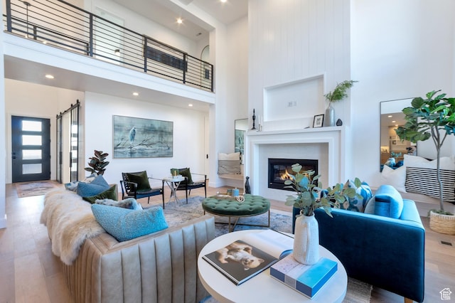 165 S Farmhouse Cir, Kaysville, UT 84037 - living area featuring a high ceiling, wood finished floors, and a glass covered fireplace