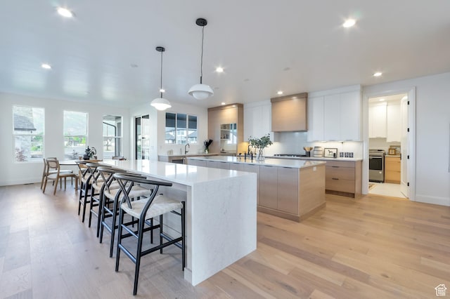 165 S Farmhouse Cir, Kaysville, UT 84037 - kitchen featuring a spacious island, modern cabinets, range, recessed lighting, and light wood-style floors