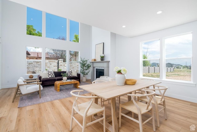 2960 N 1080 W, Lehi, UT 84043 - dining space featuring a fireplace, plenty of natural light, light wood-type flooring, recessed lighting, and a high ceiling
