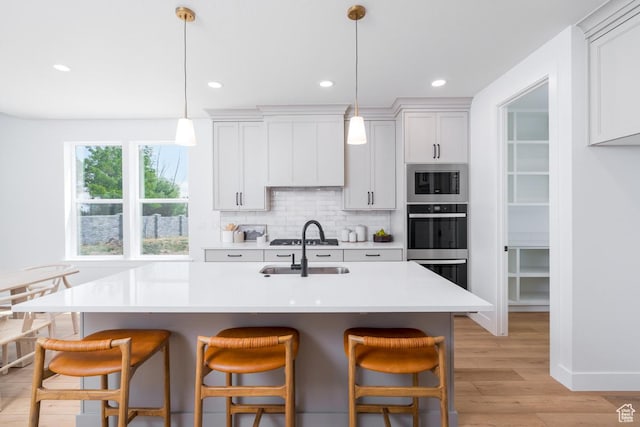 2960 N 1080 W, Lehi, UT 84043 - kitchen featuring appliances with stainless steel finishes, a breakfast bar area, light wood-type flooring, backsplash, and recessed lighting