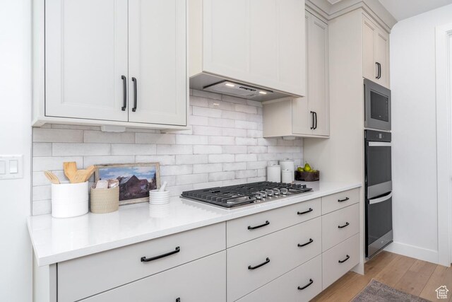 2960 N 1080 W, Lehi, UT 84043 - kitchen featuring stainless steel appliances, light wood-style flooring, tasteful backsplash, light countertops, and white cabinets