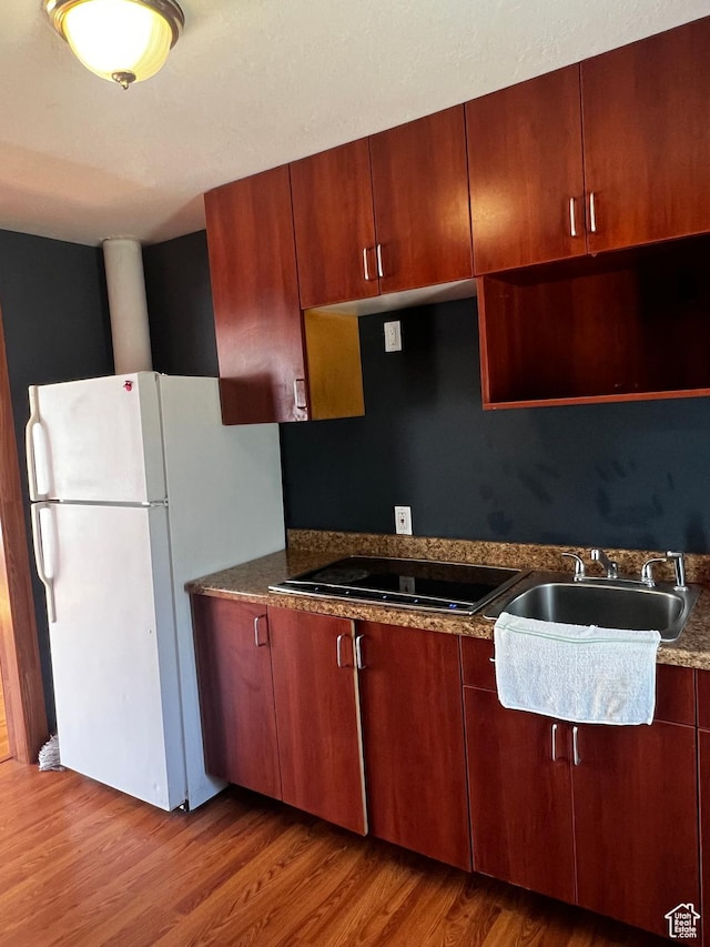 1145 S Navajo St, Salt Lake City, UT 84104 - kitchen with black electric stovetop, freestanding refrigerator, and wood finished floors
