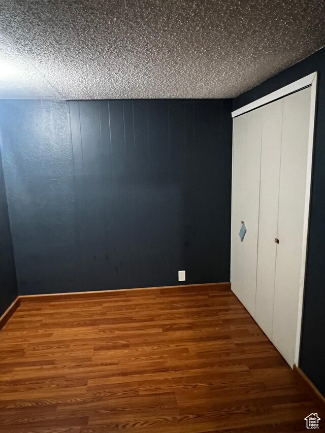 1145 S Navajo St, Salt Lake City, UT 84104 - unfurnished bedroom featuring wood finished floors, a closet, and a textured ceiling