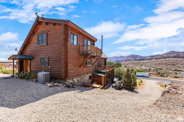 214 W Shinarump Cir, Leeds, UT 84746 - view of side of home with log siding, a balcony, and a deck with mountain view