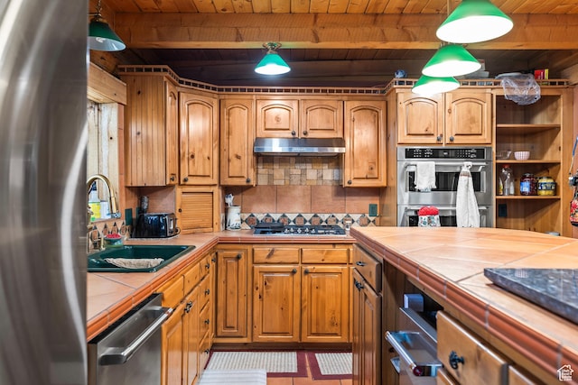 214 W Shinarump Cir, Leeds, UT 84746 - kitchen featuring tile countertops, appliances with stainless steel finishes, a wooden ceiling with exposed beams, under cabinet range hood, and decorative backsplash