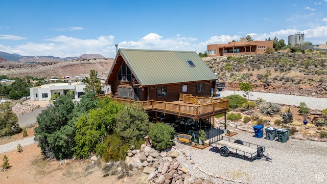214 W Shinarump Cir, Leeds, UT 84746 - back of property with log siding, a deck with mountain view, and a metal roof