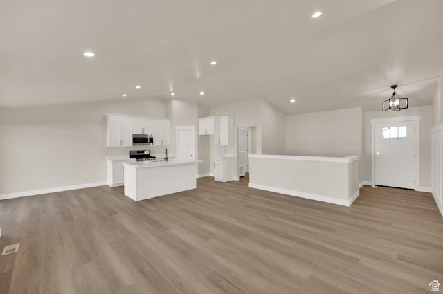 1182 N Berra Blvd, Tooele, UT 84074 - unfurnished living room featuring vaulted ceiling, light wood-style floors, recessed lighting, and a chandelier