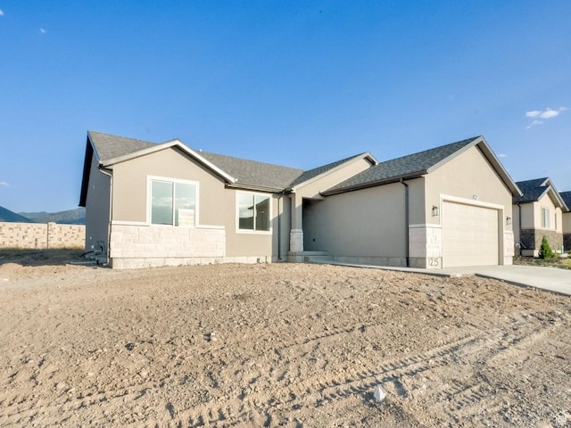 1182 N Berra Blvd, Tooele, UT 84074 - single story home with stone siding, a garage, concrete driveway, and stucco siding