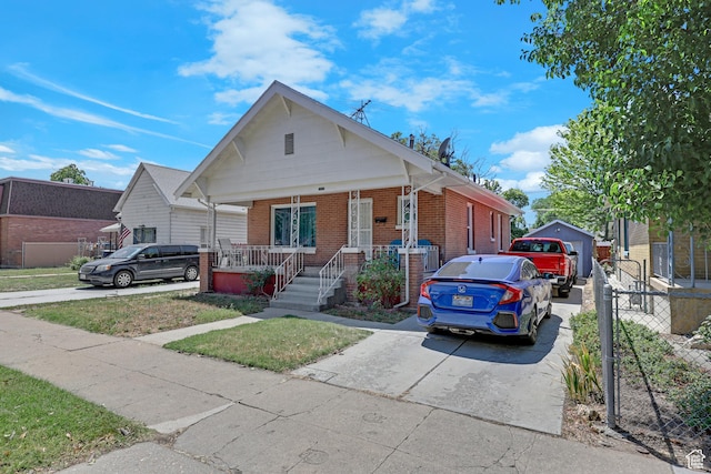 2217 Monroe Blvd, Ogden, UT 84401 - bungalow with covered porch, brick siding, and concrete driveway