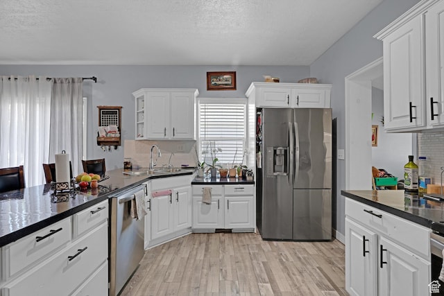 2217 Monroe Blvd, Ogden, UT 84401 - kitchen featuring appliances with stainless steel finishes, light wood-type flooring, decorative backsplash, dark countertops, and white cabinetry
