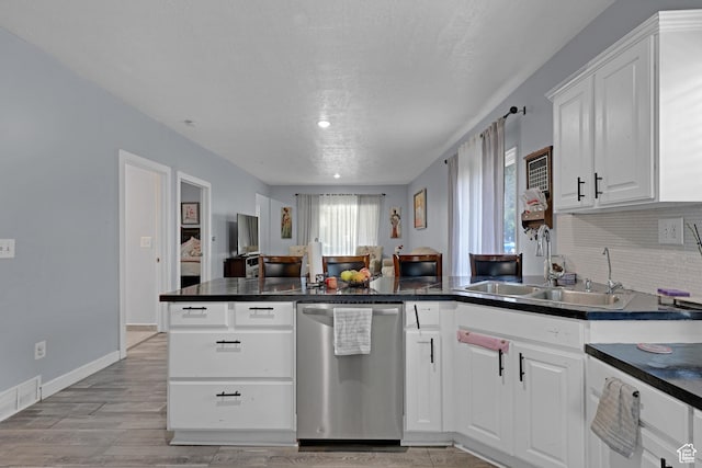 2217 Monroe Blvd, Ogden, UT 84401 - kitchen with dishwasher, a peninsula, dark countertops, and white cabinetry