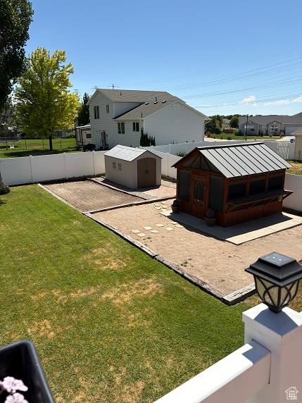 1579 W 2050 N, Clinton, UT 84015 - back of property with a standing seam roof, a storage shed, a fenced backyard, and a metal roof
