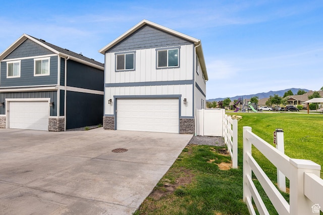 8687 N Oakmont Aly, Eagle Mountain, UT 84005 - view of front of property with board and batten siding, stone siding, an attached garage, a mountain view, and driveway