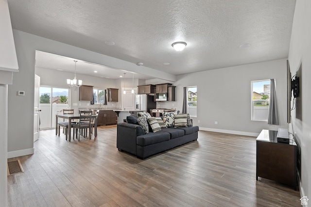 8687 N Oakmont Aly, Eagle Mountain, UT 84005 - living area featuring wood finished floors, a textured ceiling, and a chandelier