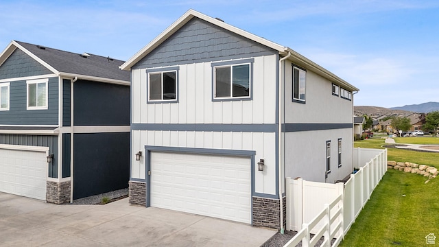 8687 N Oakmont Aly, Eagle Mountain, UT 84005 - view of front of property featuring stone siding, driveway, an attached garage, and a mountain view