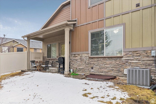 3944 W Sage Blossom Way S, Jordan, UT 84009 - snow covered property entrance with stone siding, a patio area, and board and batten siding