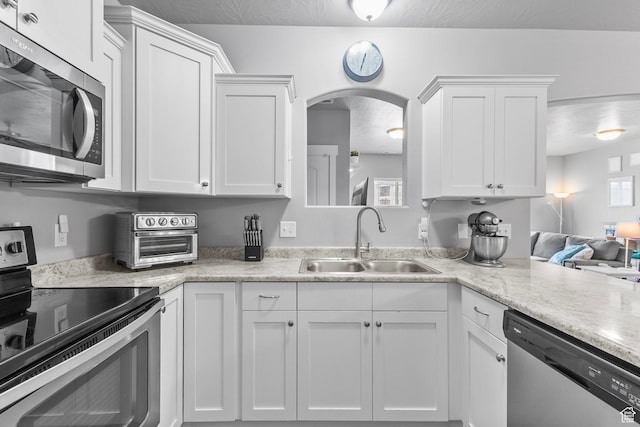 217 W Ridge Rd, Saratoga Springs, UT 84045 - kitchen with appliances with stainless steel finishes, white cabinets, and arched walkways
