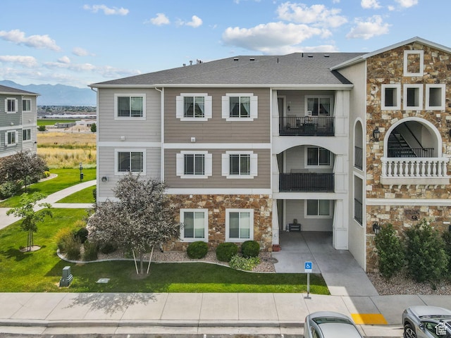 217 W Ridge Rd, Saratoga Springs, UT 84045 - view of front of property with stone siding, a mountain view, and a front yard