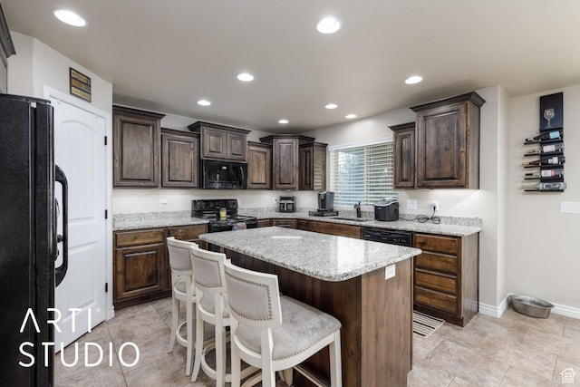 2185 N 250 W, Harrisville, UT 84414 - kitchen featuring black appliances, a kitchen island, dark brown cabinetry, a breakfast bar area, and recessed lighting