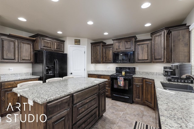 2185 N 250 W, Harrisville, UT 84414 - kitchen with black appliances, dark brown cabinetry, recessed lighting, a center island, and light stone countertops