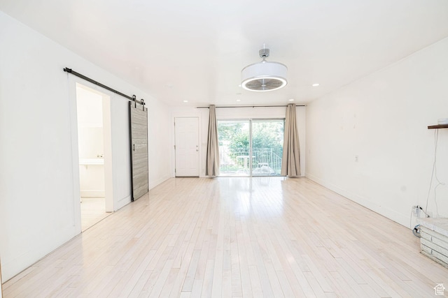 460 S 1074 E, Provo, UT 84606 - unfurnished living room featuring a barn door, light wood-style flooring, and recessed lighting