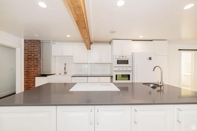 460 S 1074 E, Provo, UT 84606 - kitchen with dark countertops, a large island, white appliances, white cabinetry, and decorative backsplash