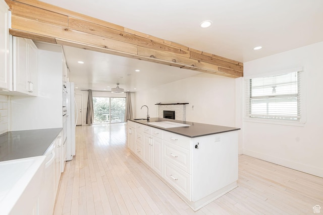 460 S 1074 E, Provo, UT 84606 - kitchen with dark countertops, a fireplace, white cabinets, light wood-style flooring, and recessed lighting