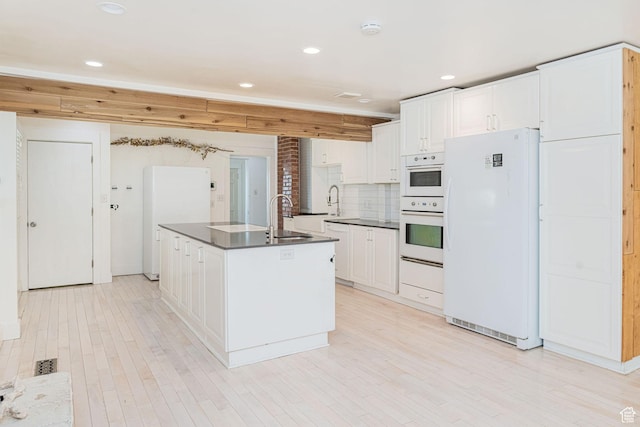 460 S 1074 E, Provo, UT 84606 - kitchen with white appliances, dark countertops, white cabinetry, a kitchen island with sink, and decorative backsplash
