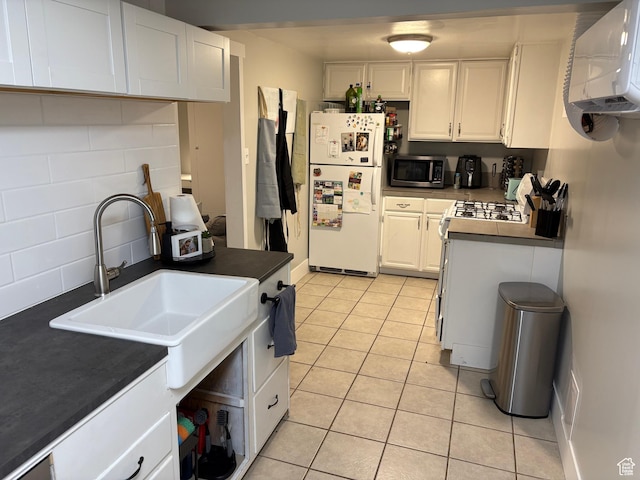 503 S Utah Ave, Provo, UT 84606 - kitchen featuring white appliances, dark countertops, decorative backsplash, light tile patterned flooring, and white cabinets