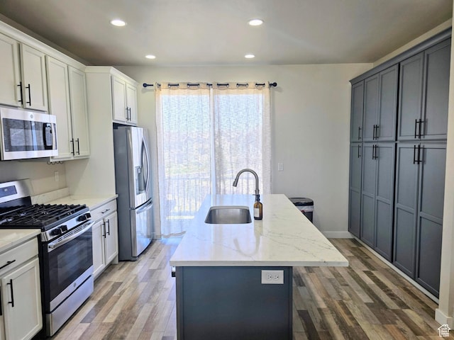 5149 W Arley Ct, Herriman, UT 84096 - kitchen featuring stainless steel appliances, an island with sink, light wood finished floors, light stone counters, and recessed lighting
