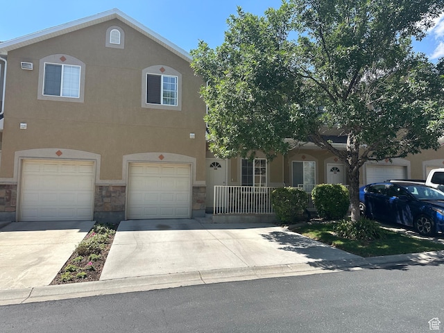 5551 W Geronimo Way S, West Jordan, UT 84081 - view of property featuring driveway, stone siding, stucco siding, and an attached garage