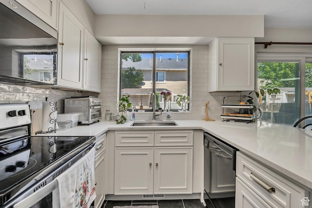 857 E 575 N, Layton, UT 84041 - kitchen featuring dishwasher, stainless steel range with electric cooktop, backsplash, white cabinets, and healthy amount of natural light